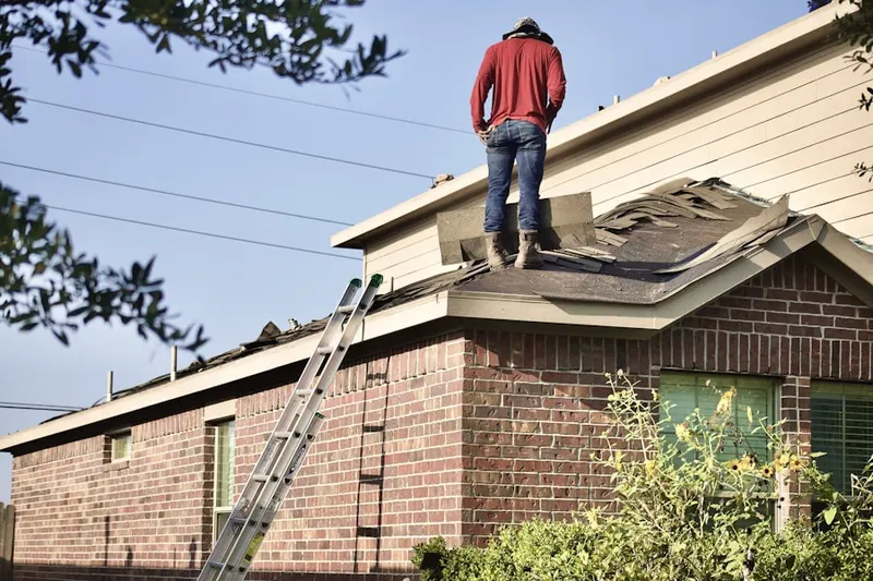 Professional roofer working on a residential roof in Enoch